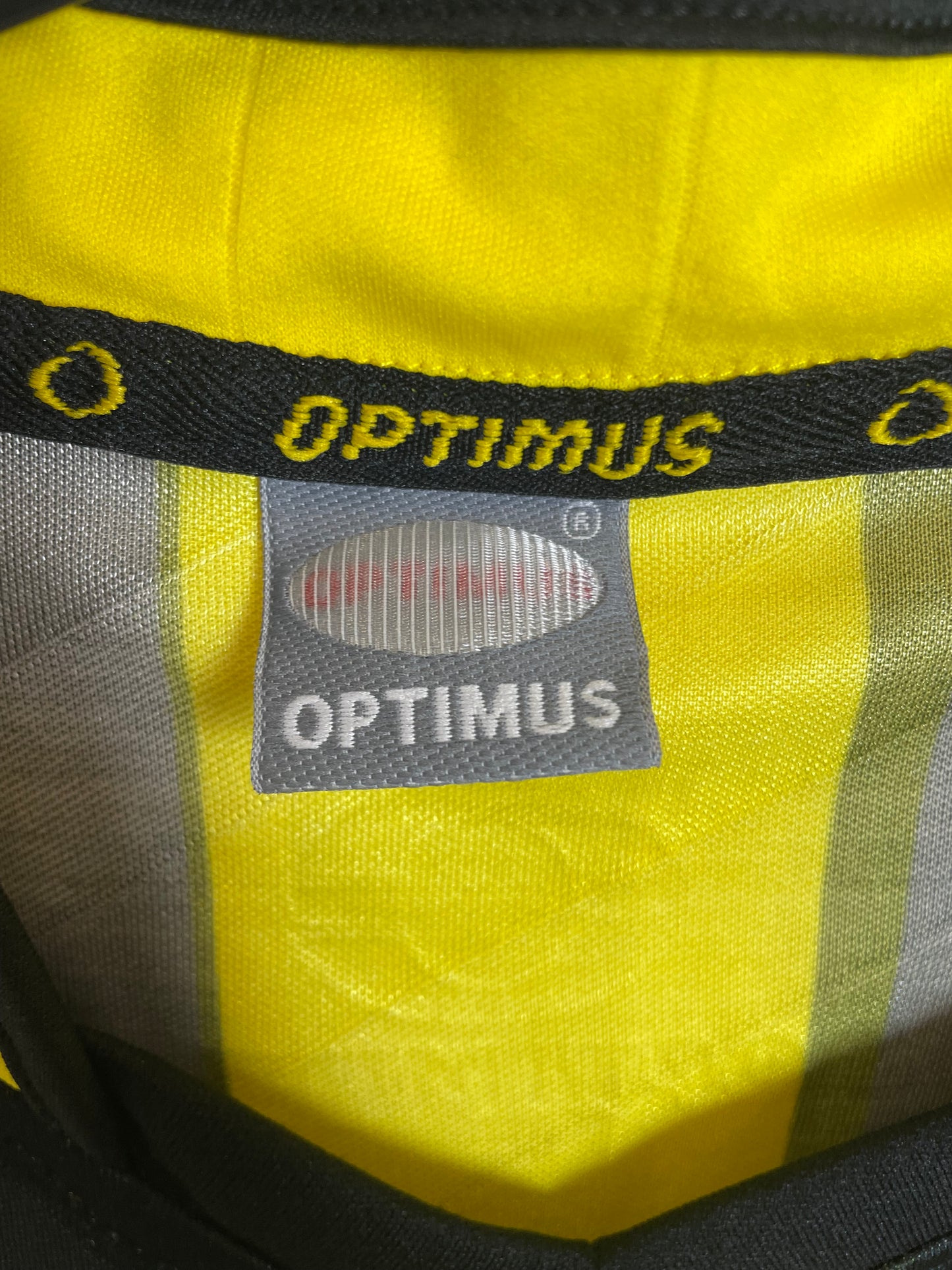 The Strongest home shirt — club crest and Optimus brand detail
