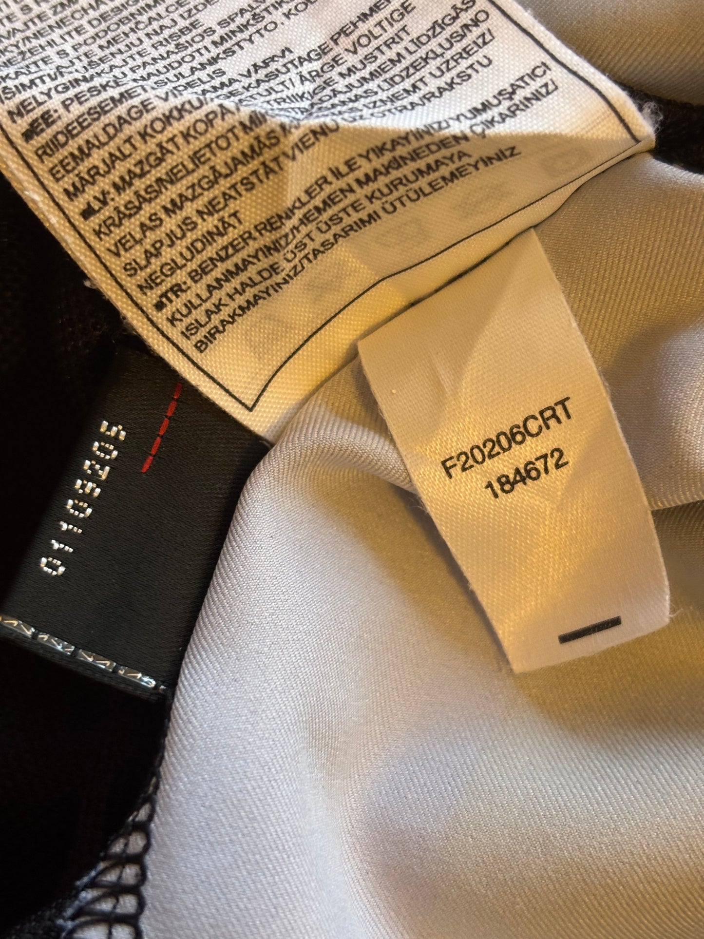 Close-up of clothing tags with text and numbers on a fabric background