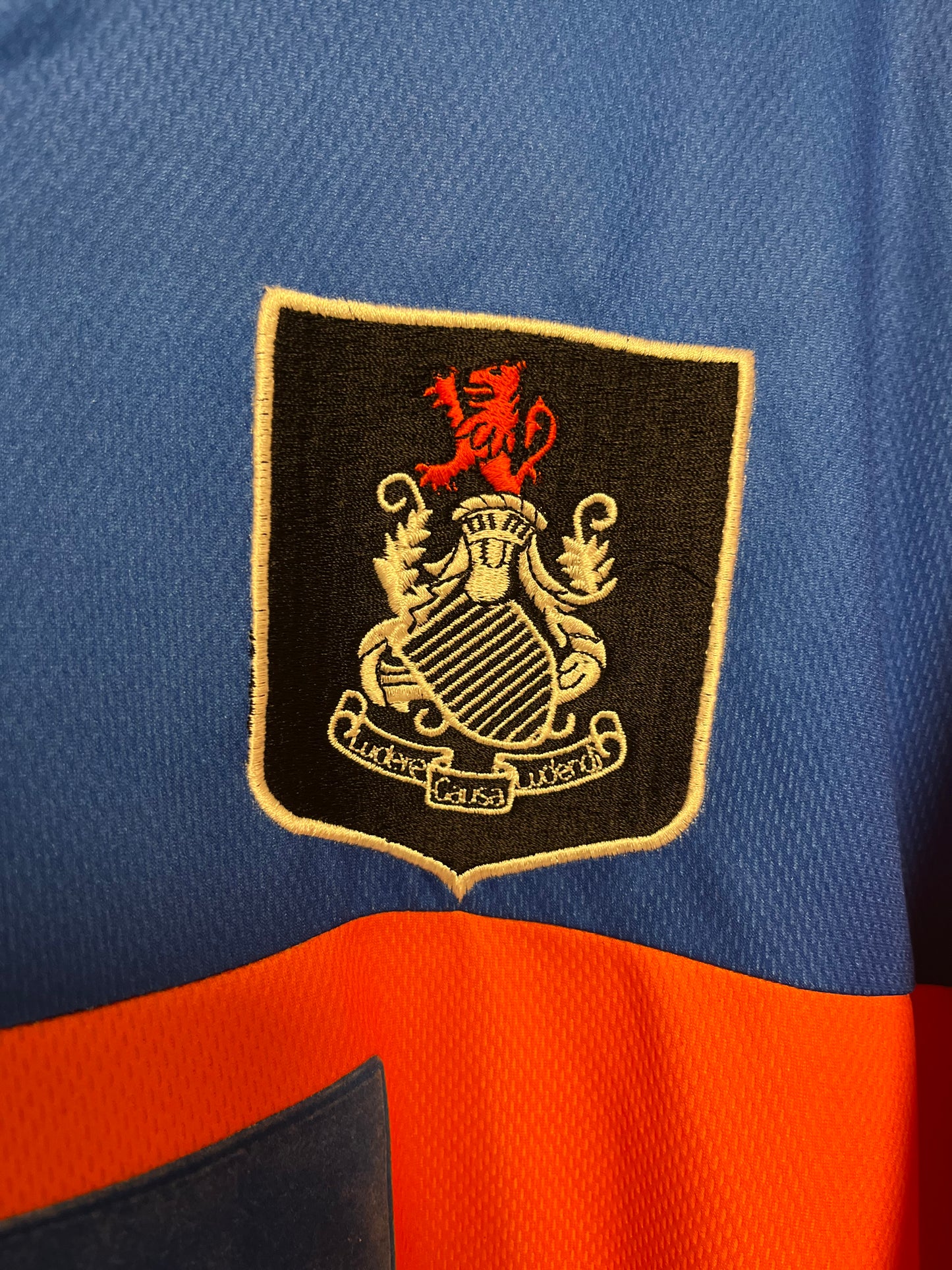 Embroidered logo on a blue and orange sports jersey