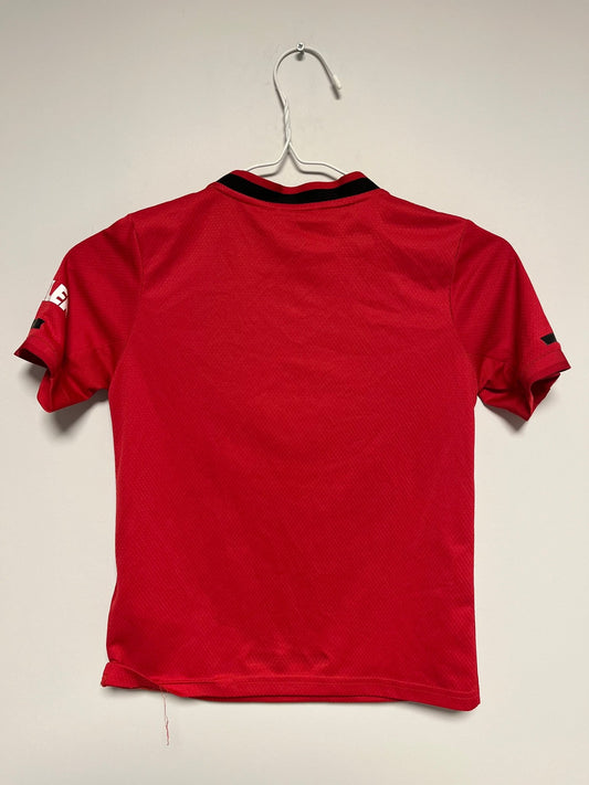 Front view of the Manchester United 19/20 kids home shirt showing the badge and sponsor, photographed at our Stavanger store