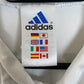 Close-up of Real Madrid club crest and Adidas three stripes on white 01/02 home jersey