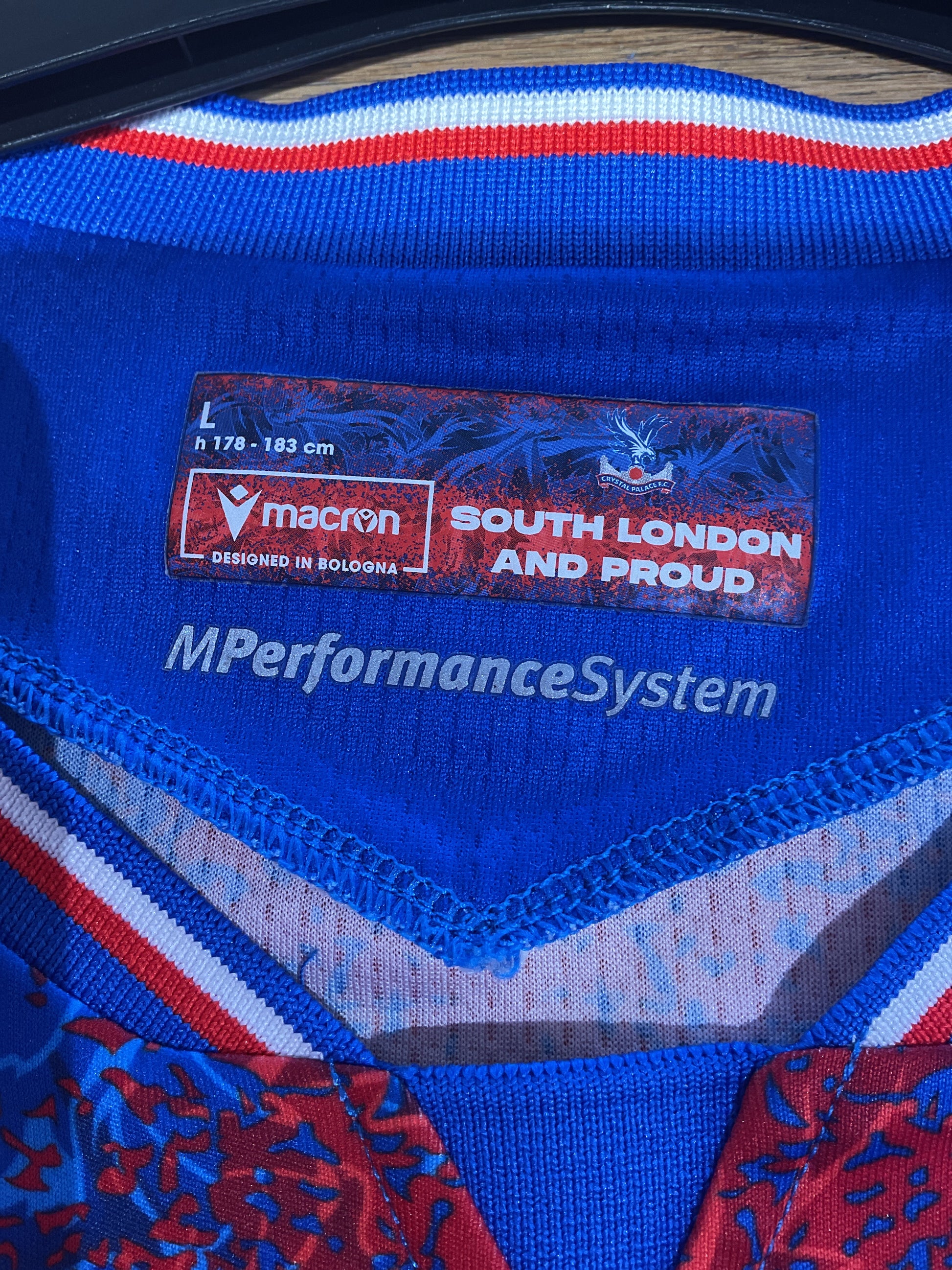 macron Blue sports shoe with branding and text on a blurred background