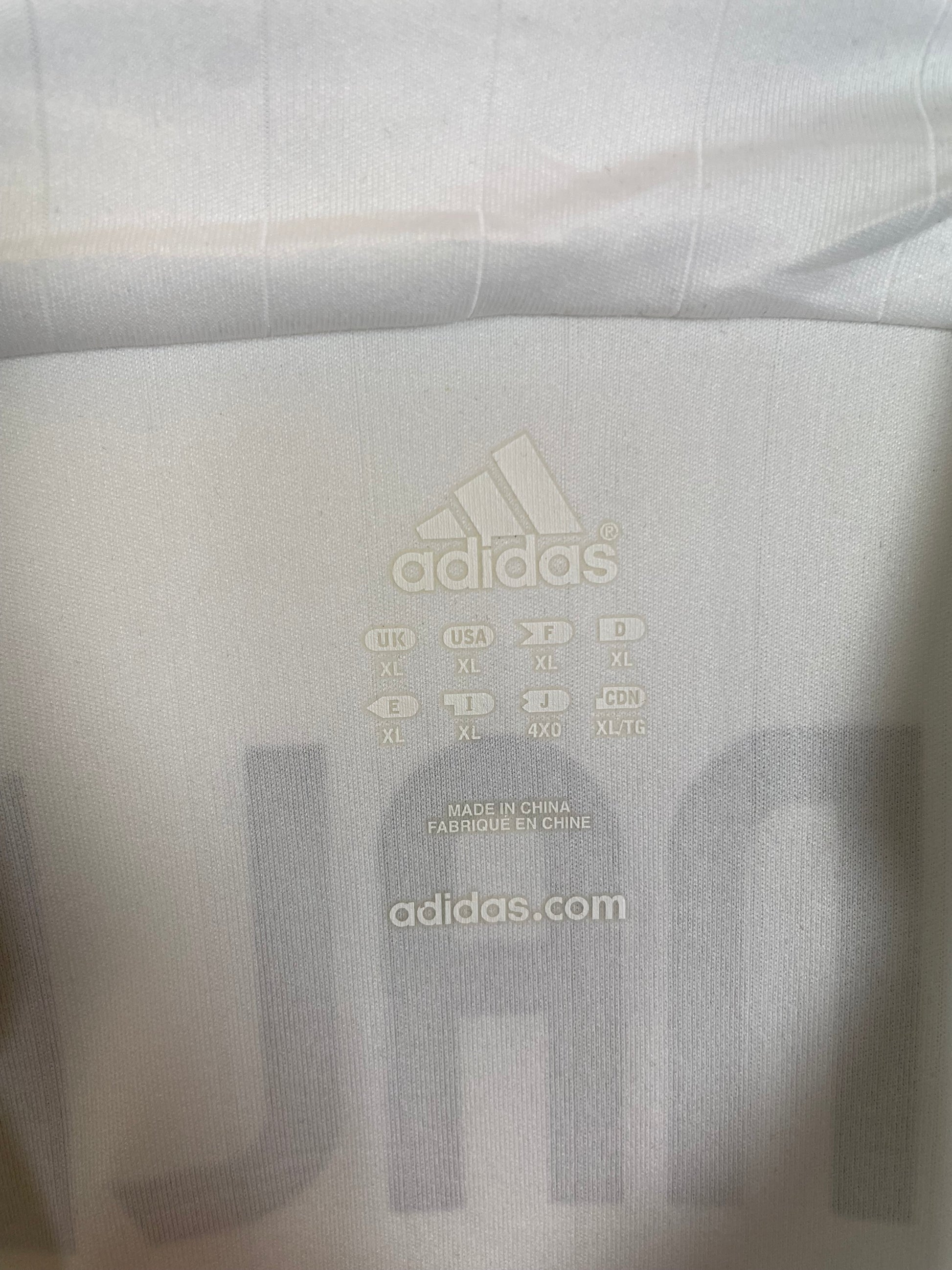 Close-up of Adidas logo and Real Madrid club badge on white 06/07 home shirt with Ronaldo 9