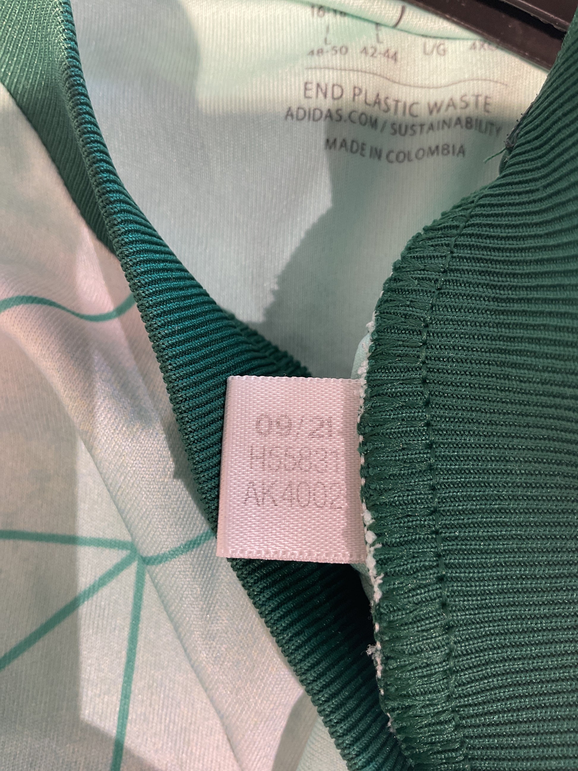Close-up of a green fabric with a pink label on a white background