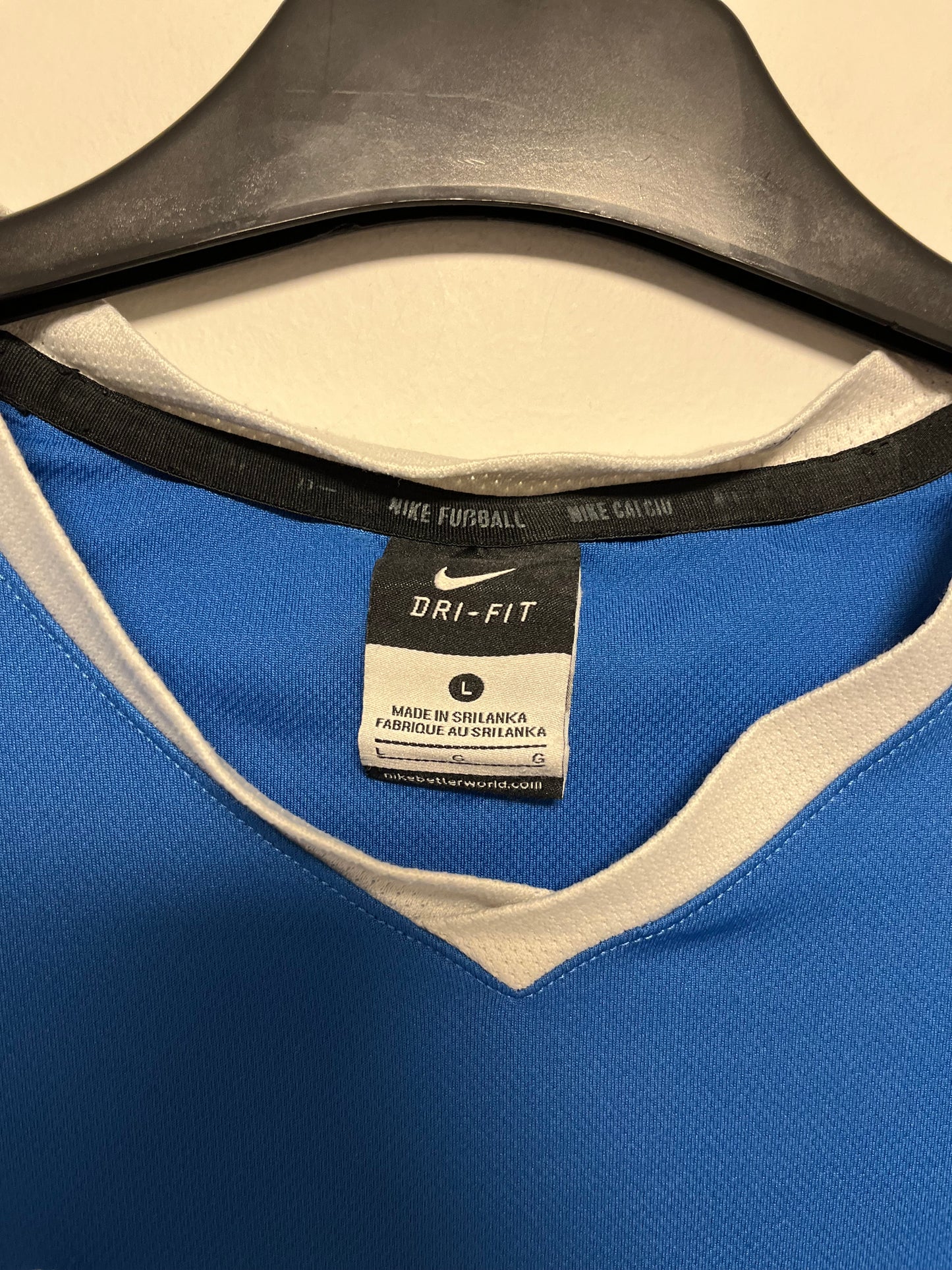 Close-up of a Nike Fit label on a blue sports garment with beige interior.