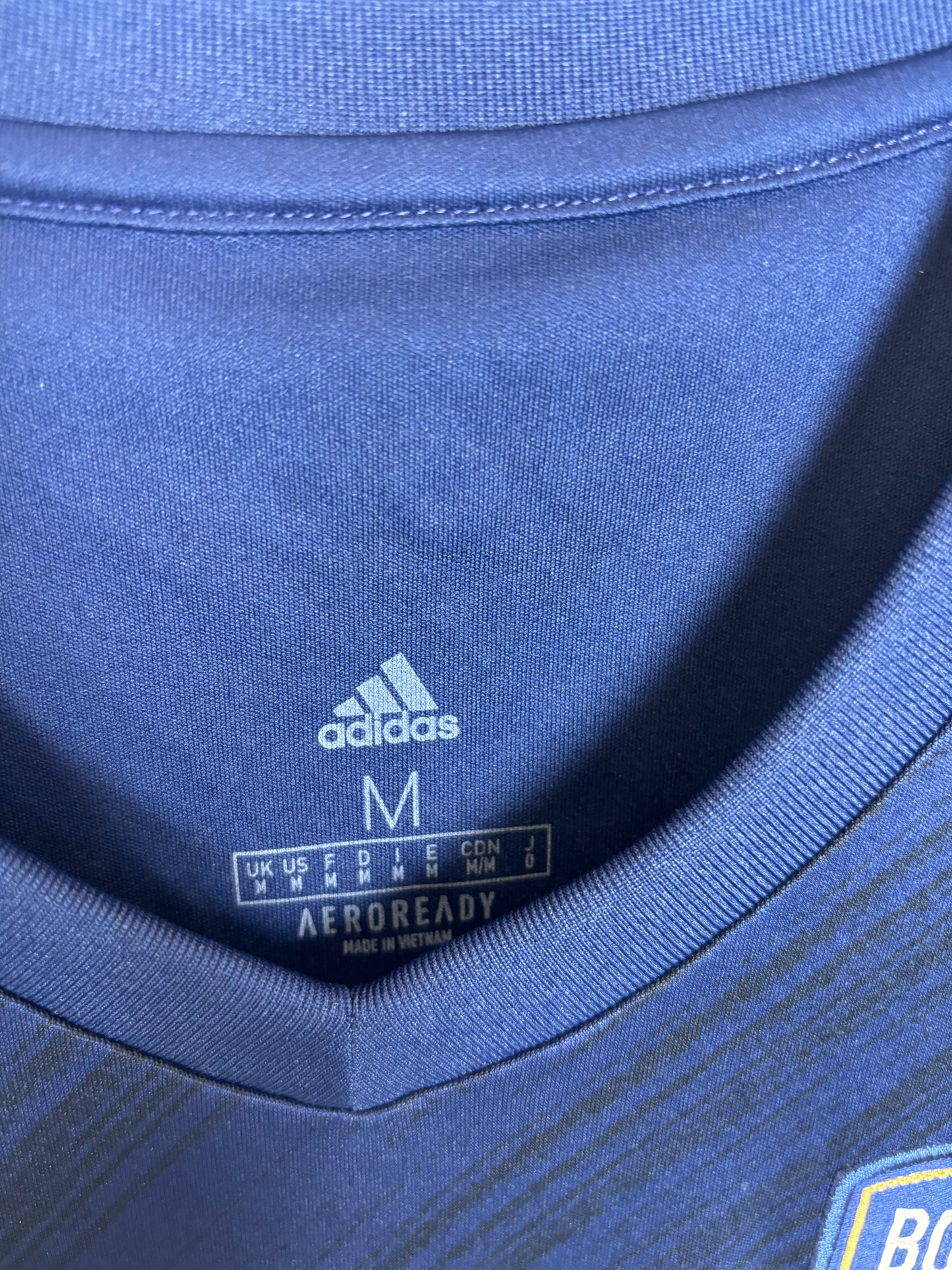 Close-up of Adidas logo and Bordeaux club badge on navy blue home shirt 20/21