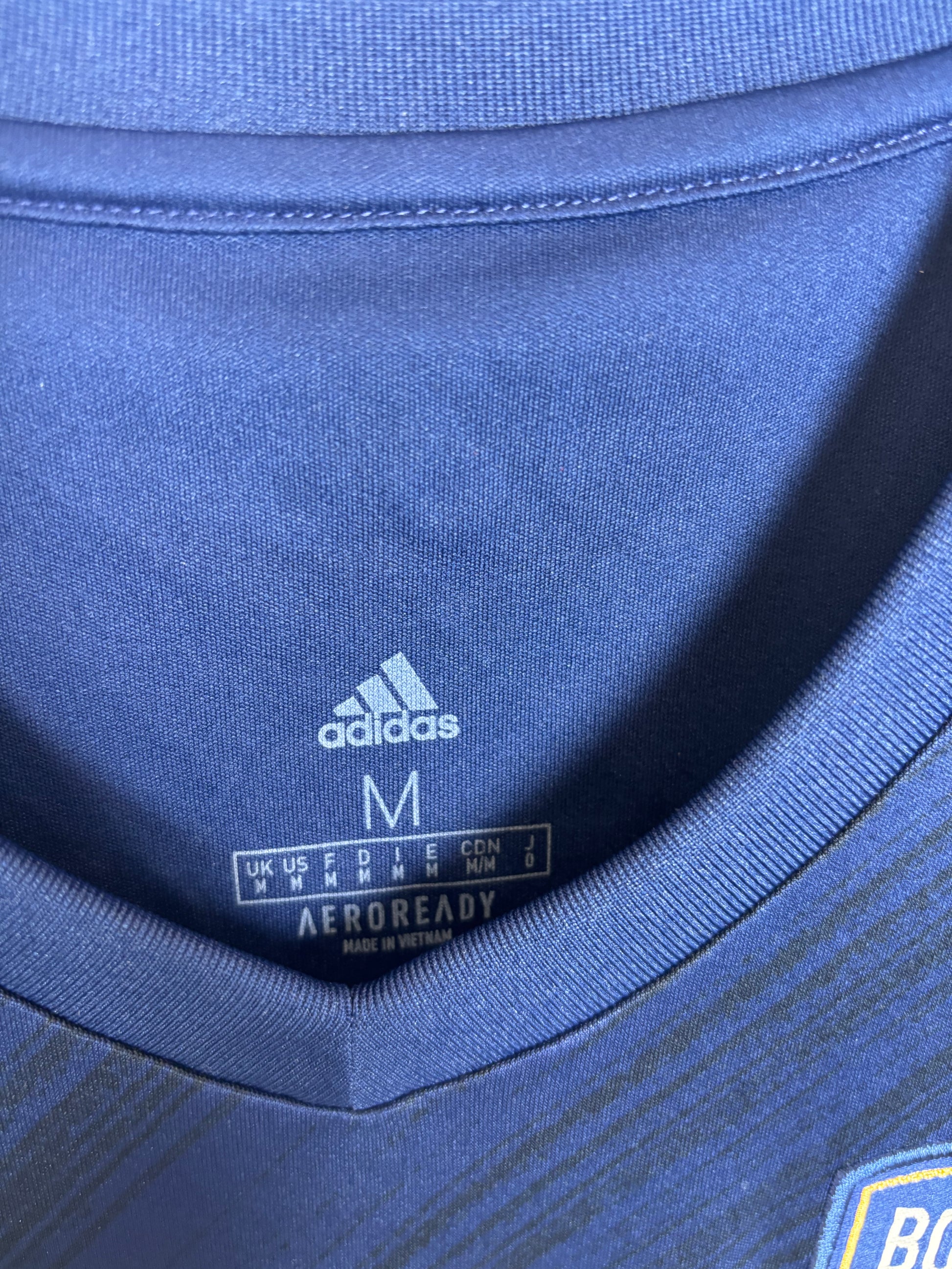 Close-up of Adidas logo and Bordeaux club badge on navy blue home shirt 20/21