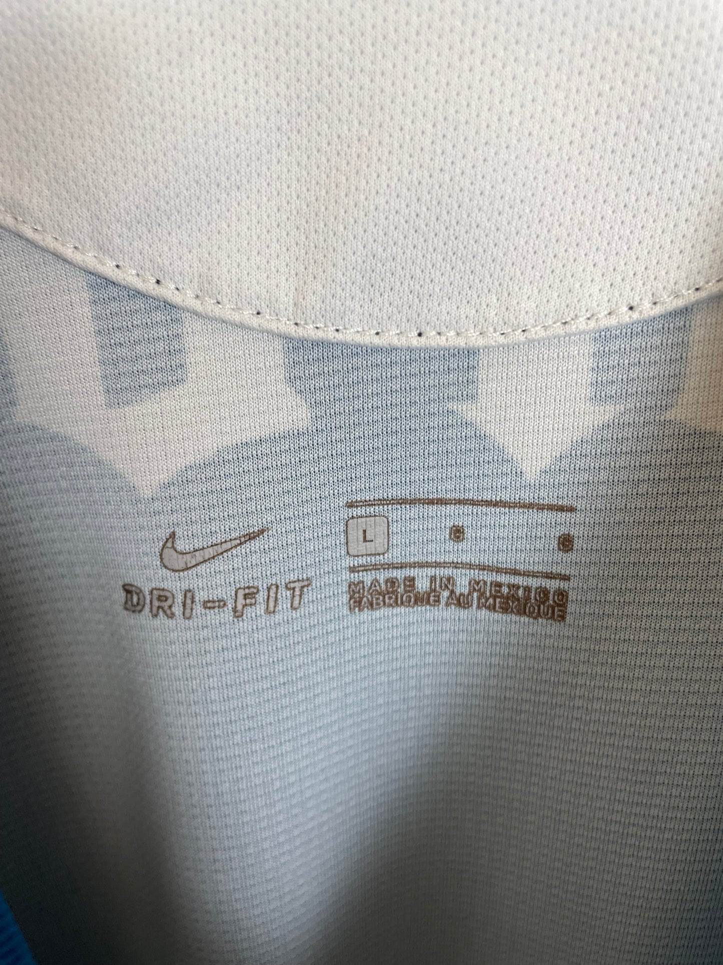Close-up of Club América eagle crest and Nike swoosh logo on yellow 20/21 home kit