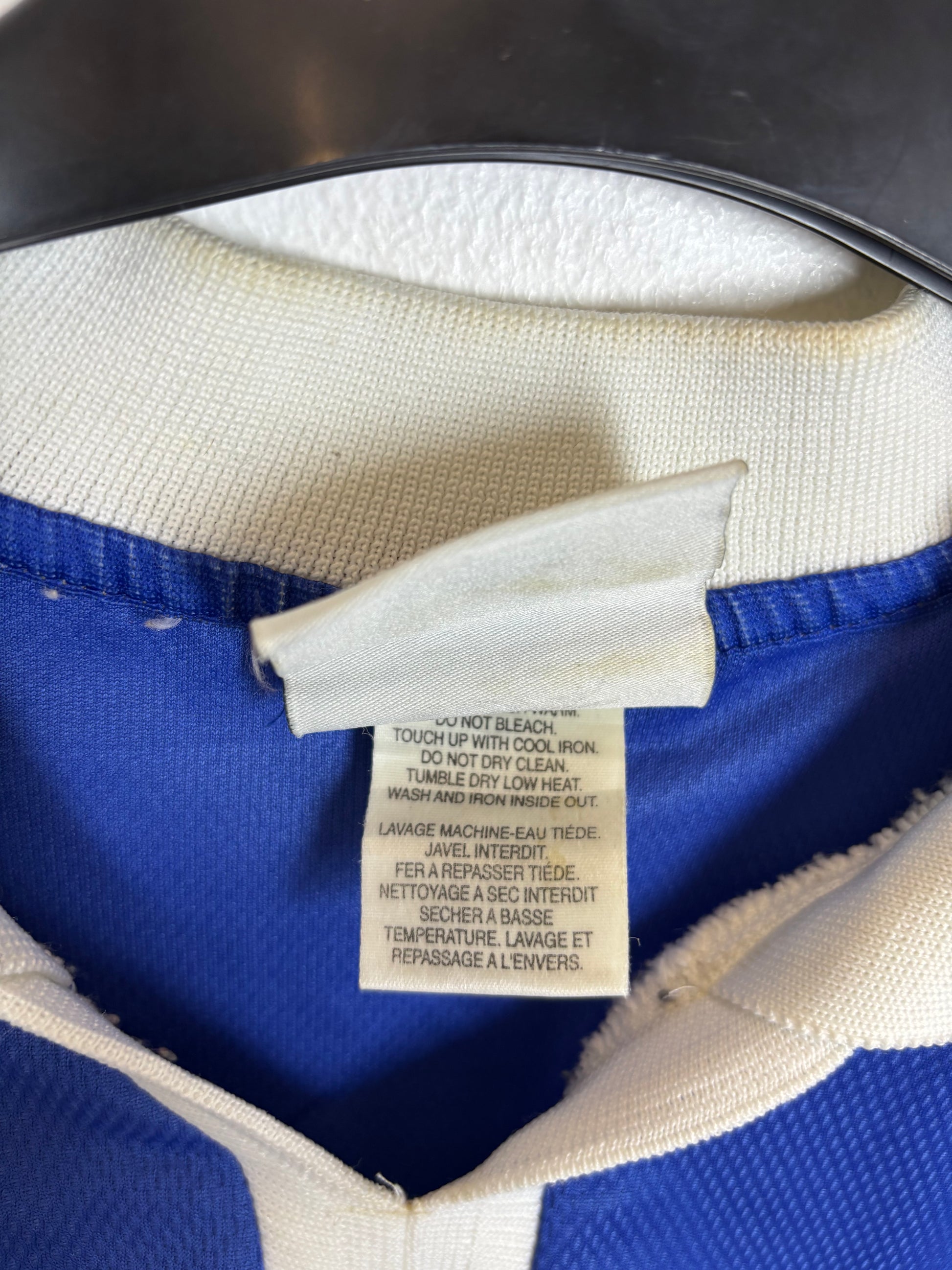 Close-up of a label on a blue and white garment with a blurred background