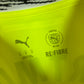 Close-up of Borussia Dortmund club badge and Puma logo on yellow 2024/25 home jersey