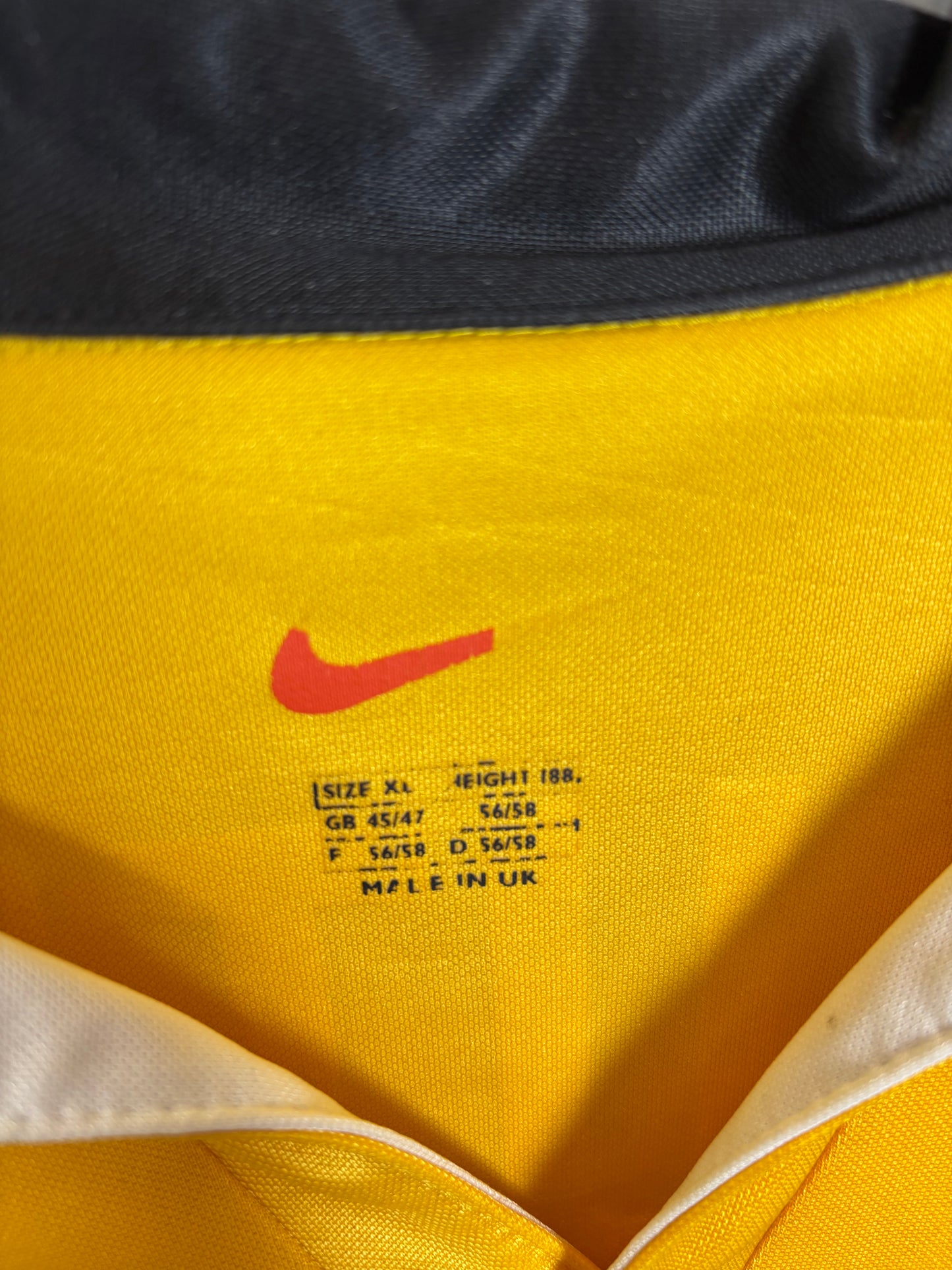 Close-up of Nike logo and Borussia Dortmund club badge on vintage 98/00 yellow home shirt