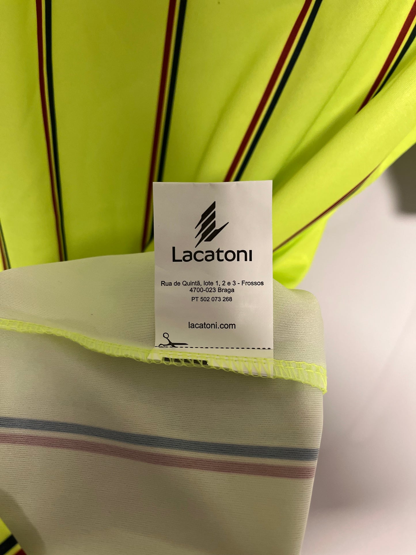 Close-up of a Lacoste label on a striped garment with a neutral background
