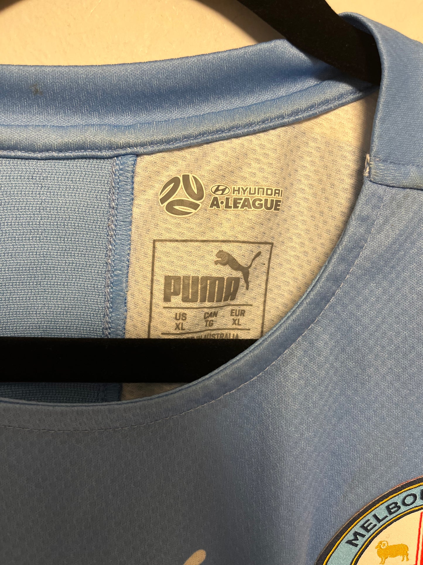 Close-up of a blue cap with a brand label and logo on a beige background