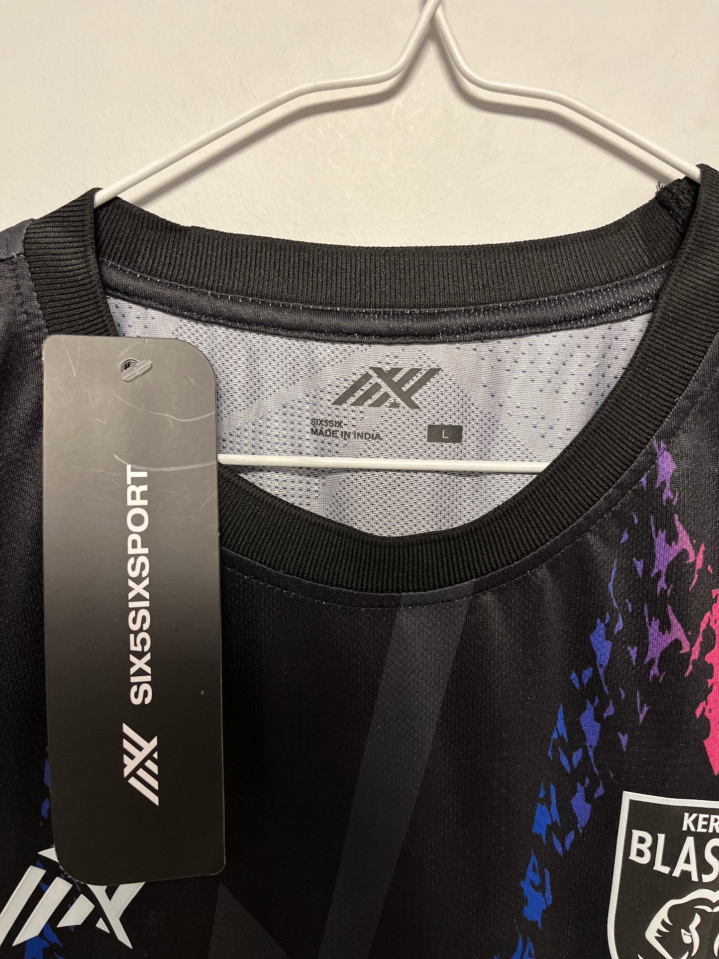 Black sports vest with colorful graphics and branding on a beige background