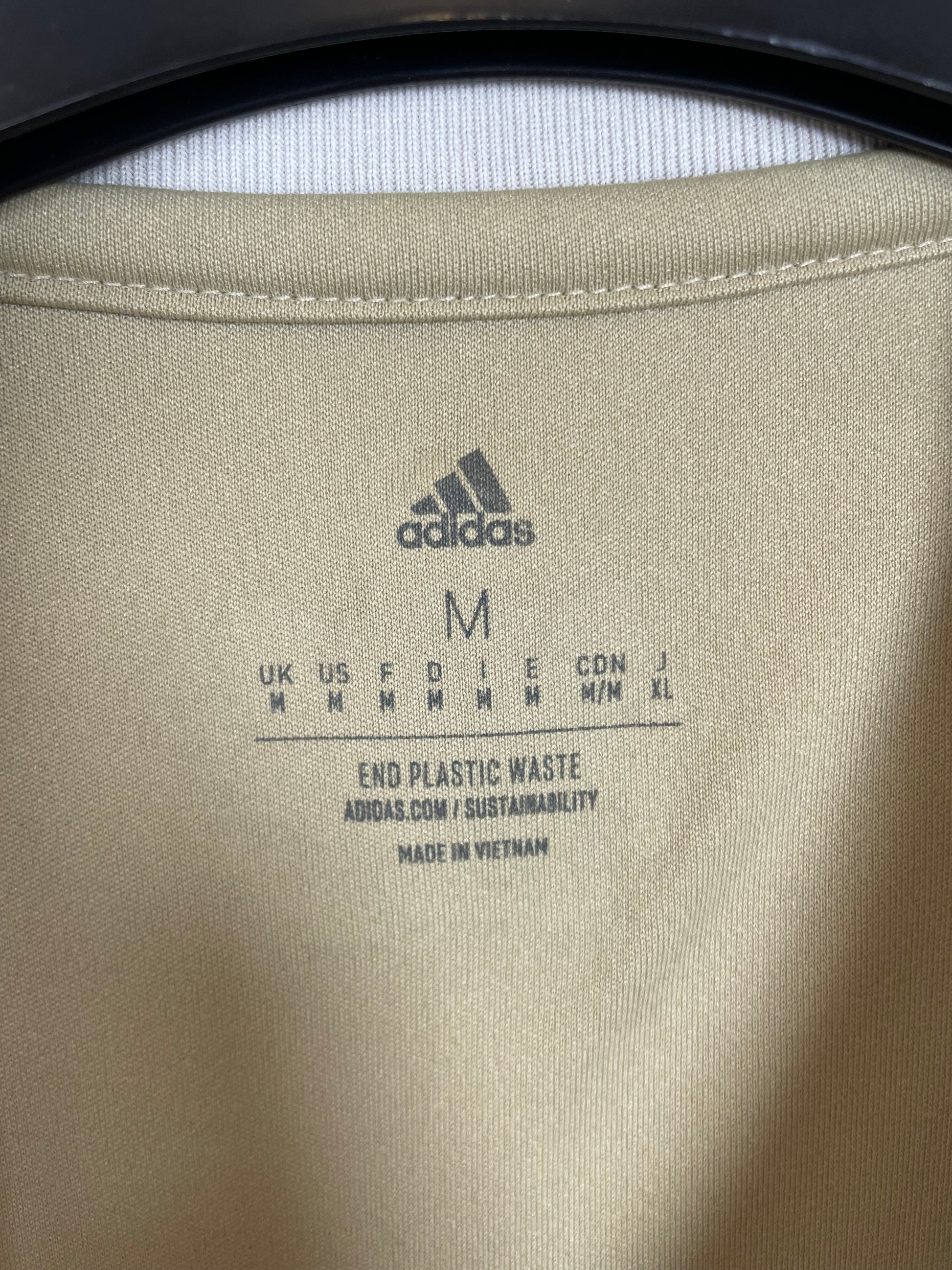 Close-up of Adidas logo and Ajax club badge on white third shirt from 2022/23 season