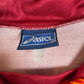 Close-up of a red fabric with an Asics logo tag.