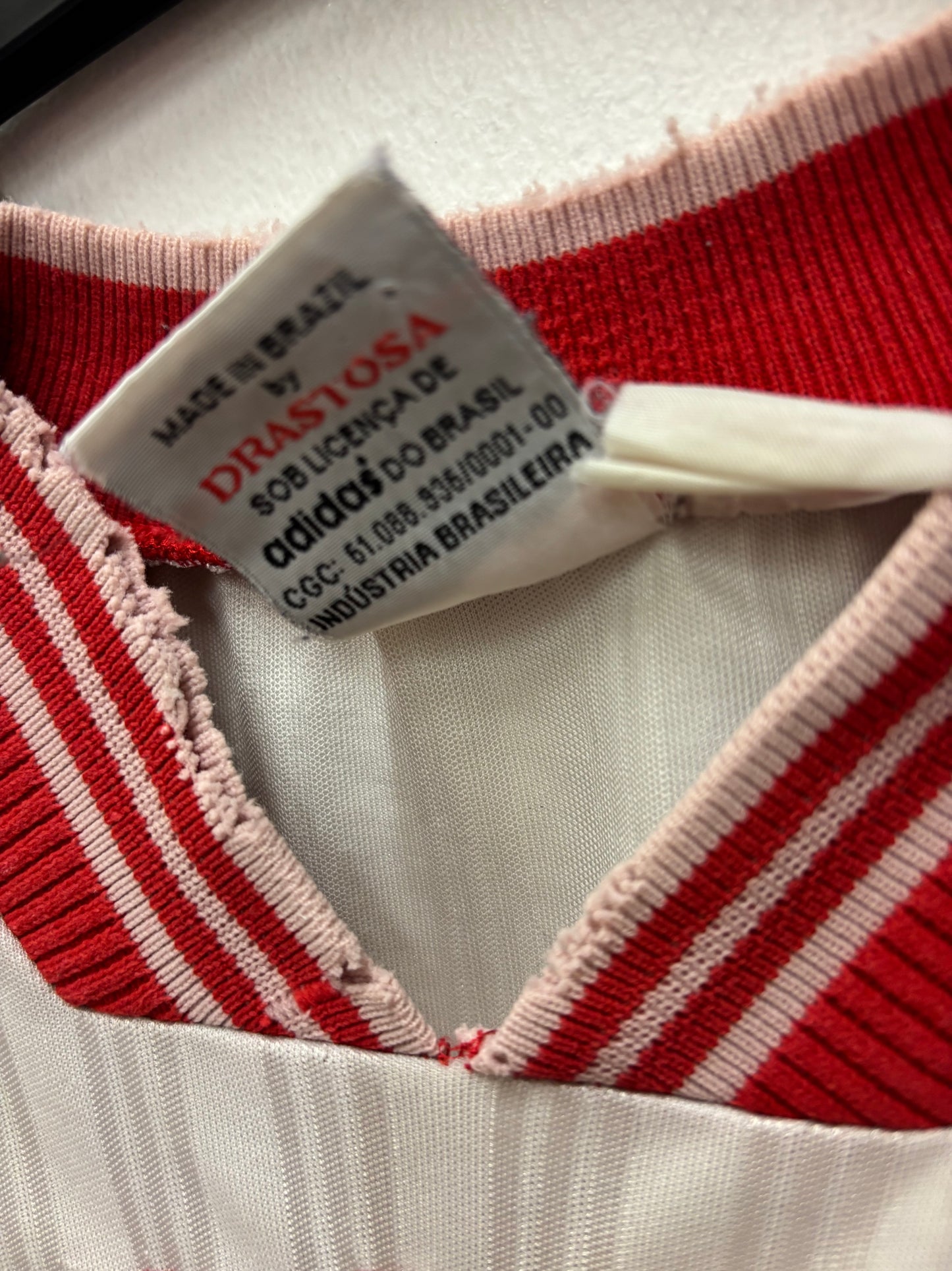 Close-up of a red and white striped fabric with a label on a white background