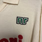 Close-up of a beige fabric with a green and white Nr Shirt  on the left and red text on the right.