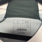 Close-up of Adidas logo and Manchester United club badge on 2023/24 away shirt
