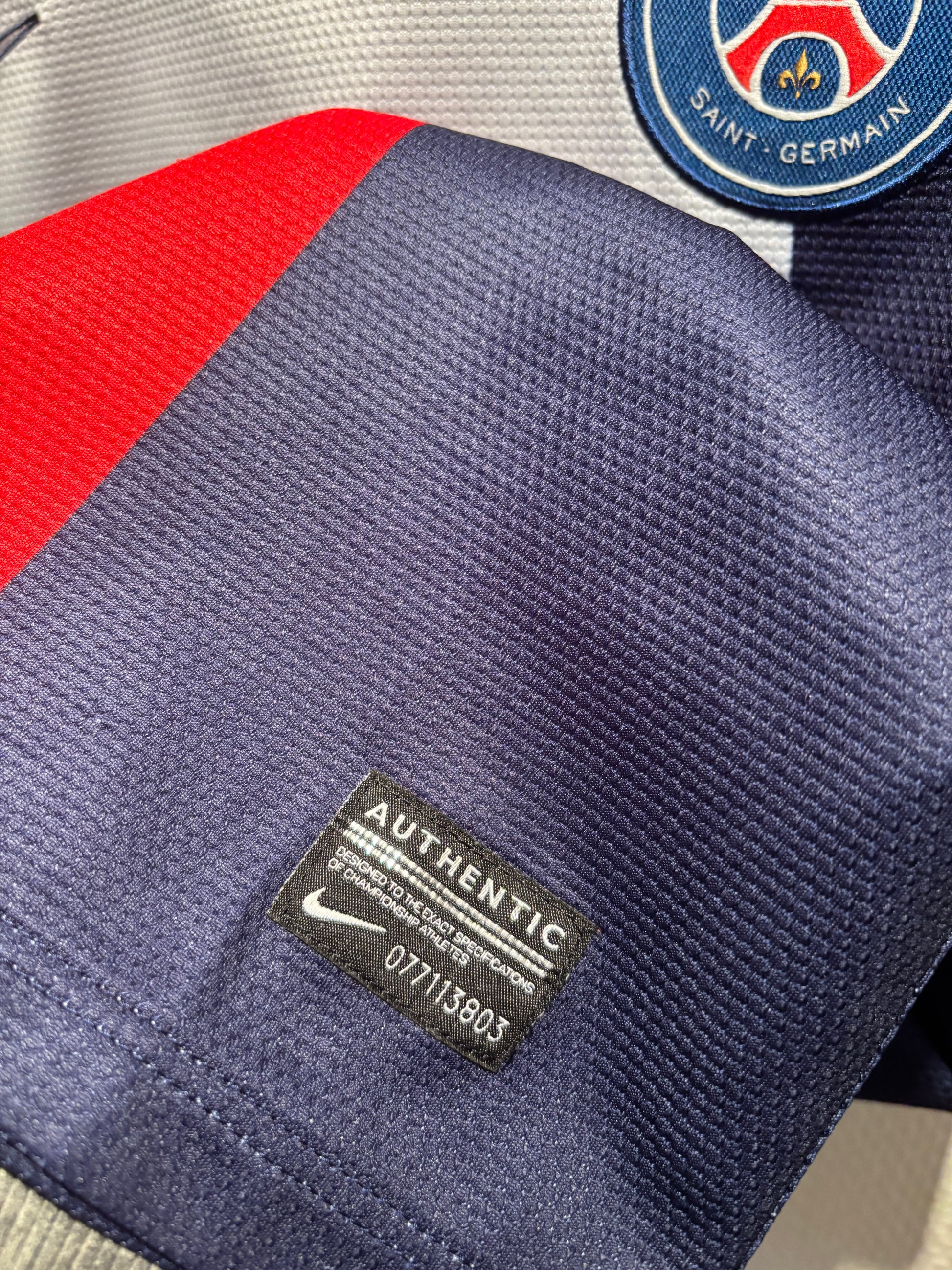 Close-up of a nike footbaldrakter jersey with an 'Authentic' label and club emblem.