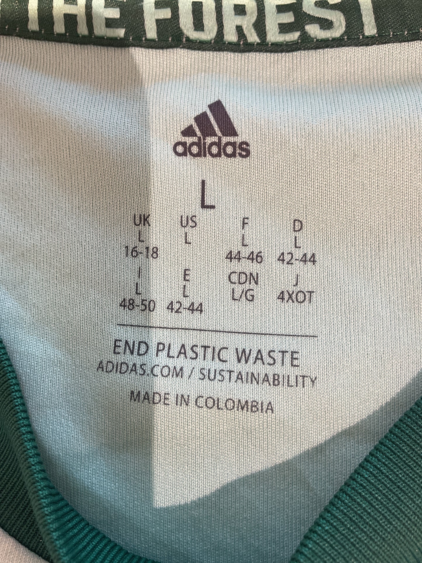 Close-up of an Adidas label on a product with sustainability text.