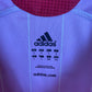 Close-up of Spain national team crest and Adidas three stripes on 06/08 red home jersey