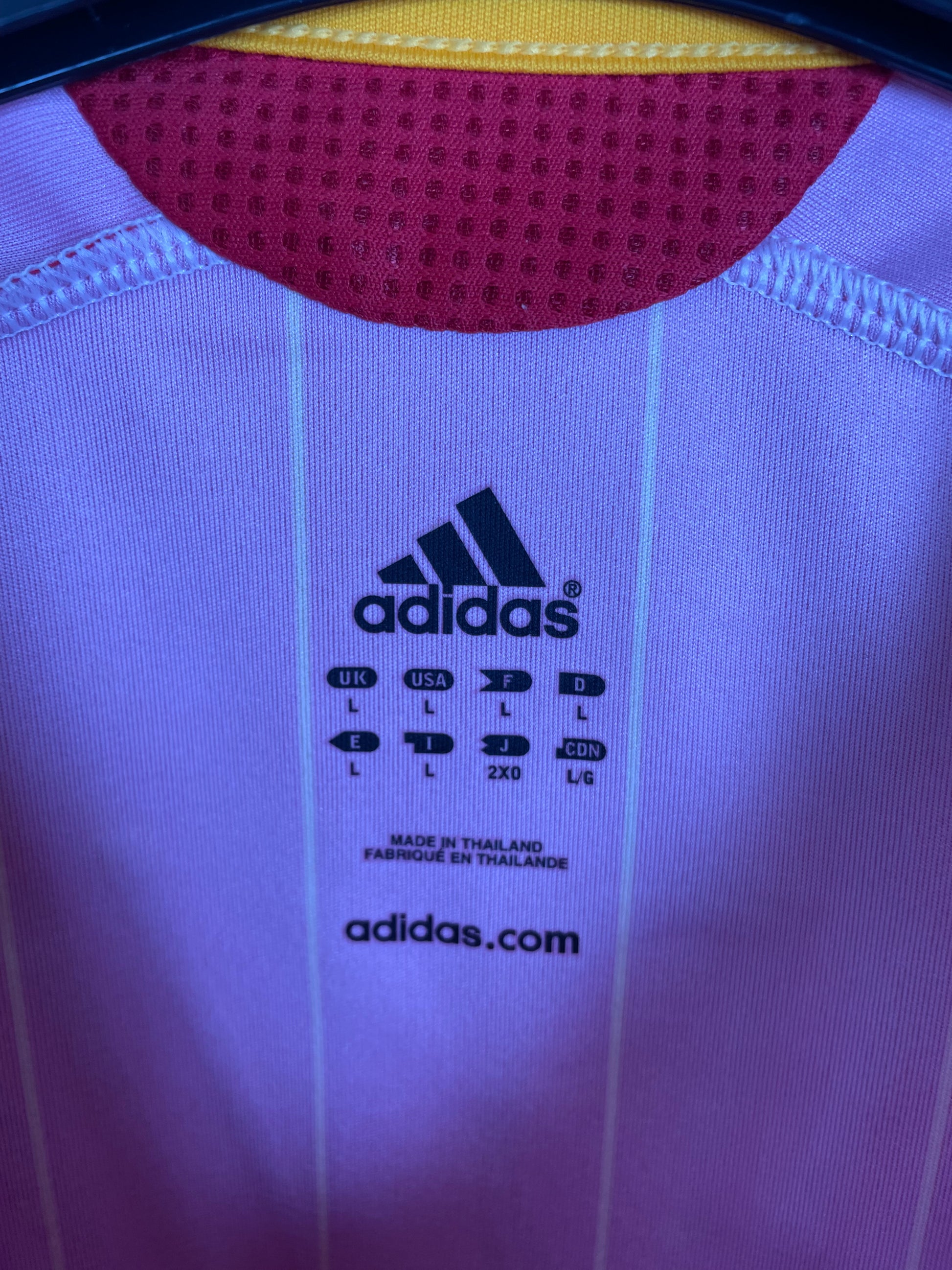 Close-up of Spain national team crest and Adidas three stripes on 06/08 red home jersey
