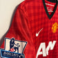 Close-up of Nike swoosh and Manchester United club badge on red 12/13 home shirt
