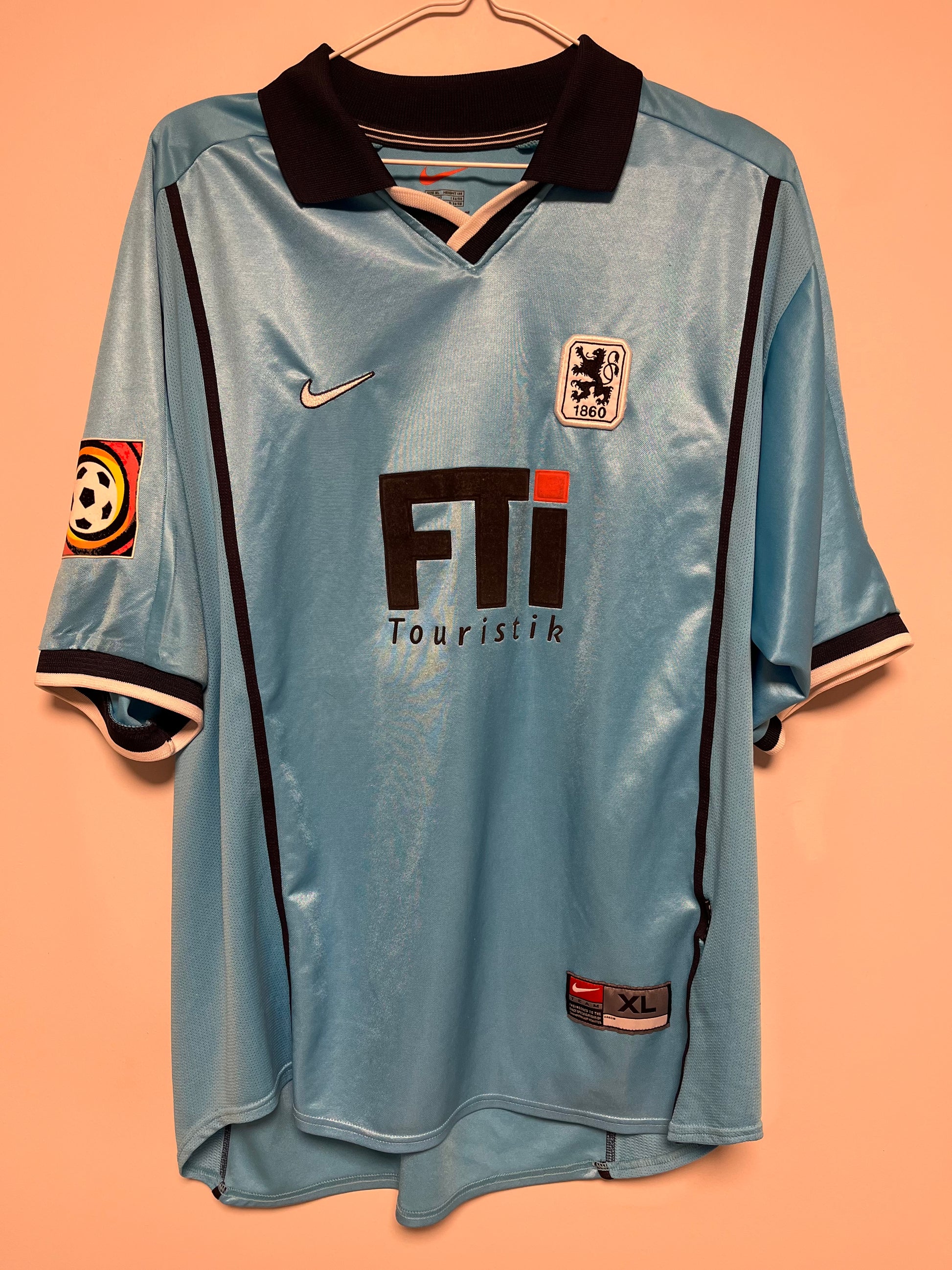 Light blue 80s football jersey with black accents on a peach background