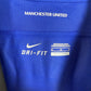 Close-up of Manchester United club badge on Nike 2011-13 away shirt showing red devil crest detail