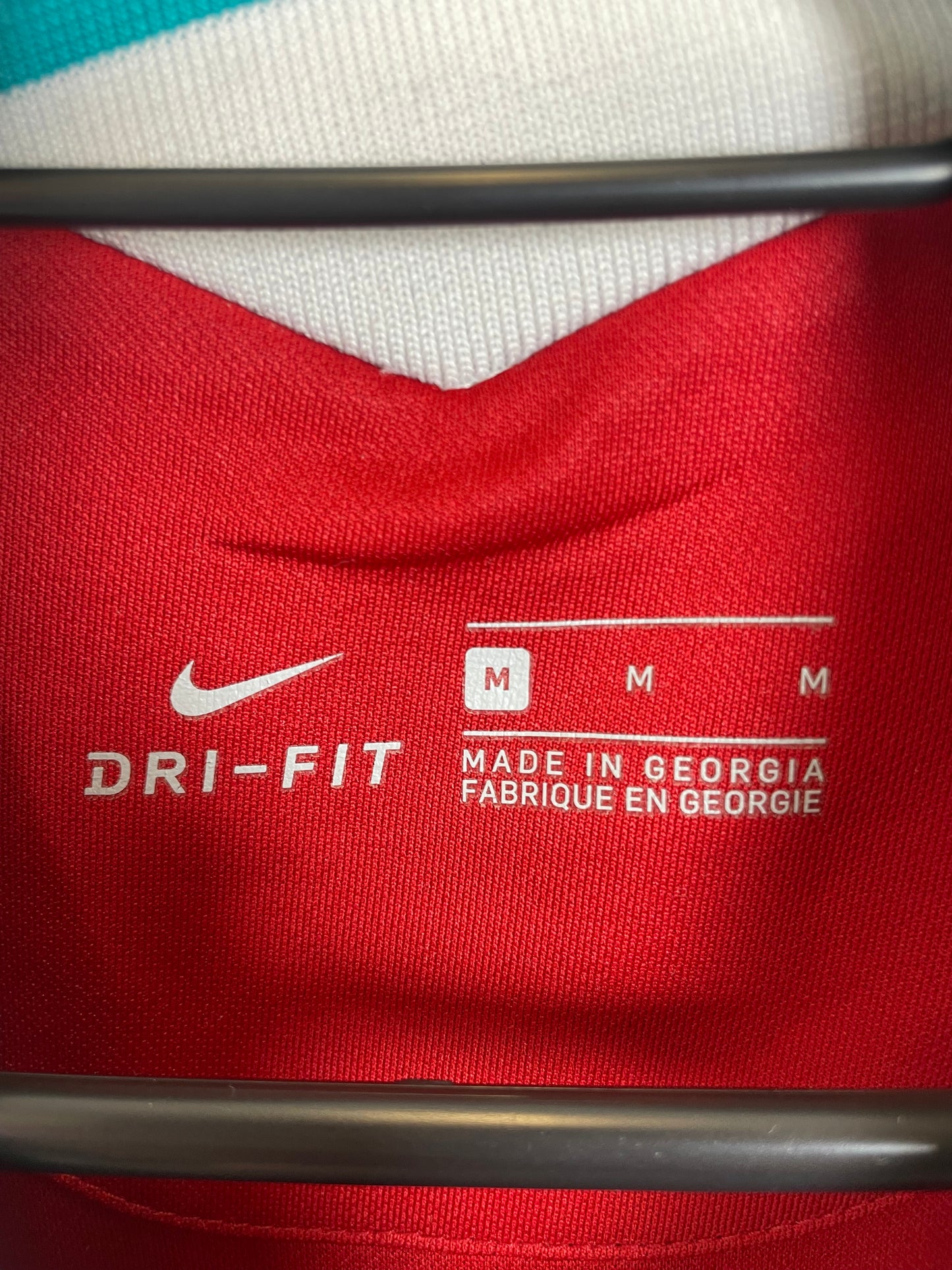 Close-up of Liverpool FC club badge and Standard Chartered sponsor on Nike 20/21 home shirt