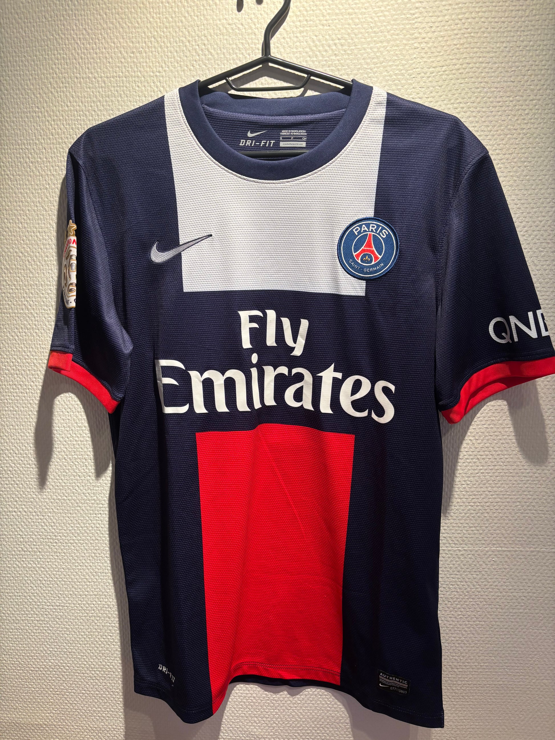 Paris Saint-Germain football jersey with Emirates logo on a textured surface
