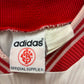 Close-up of an Adidas label on a red and white striped fabric