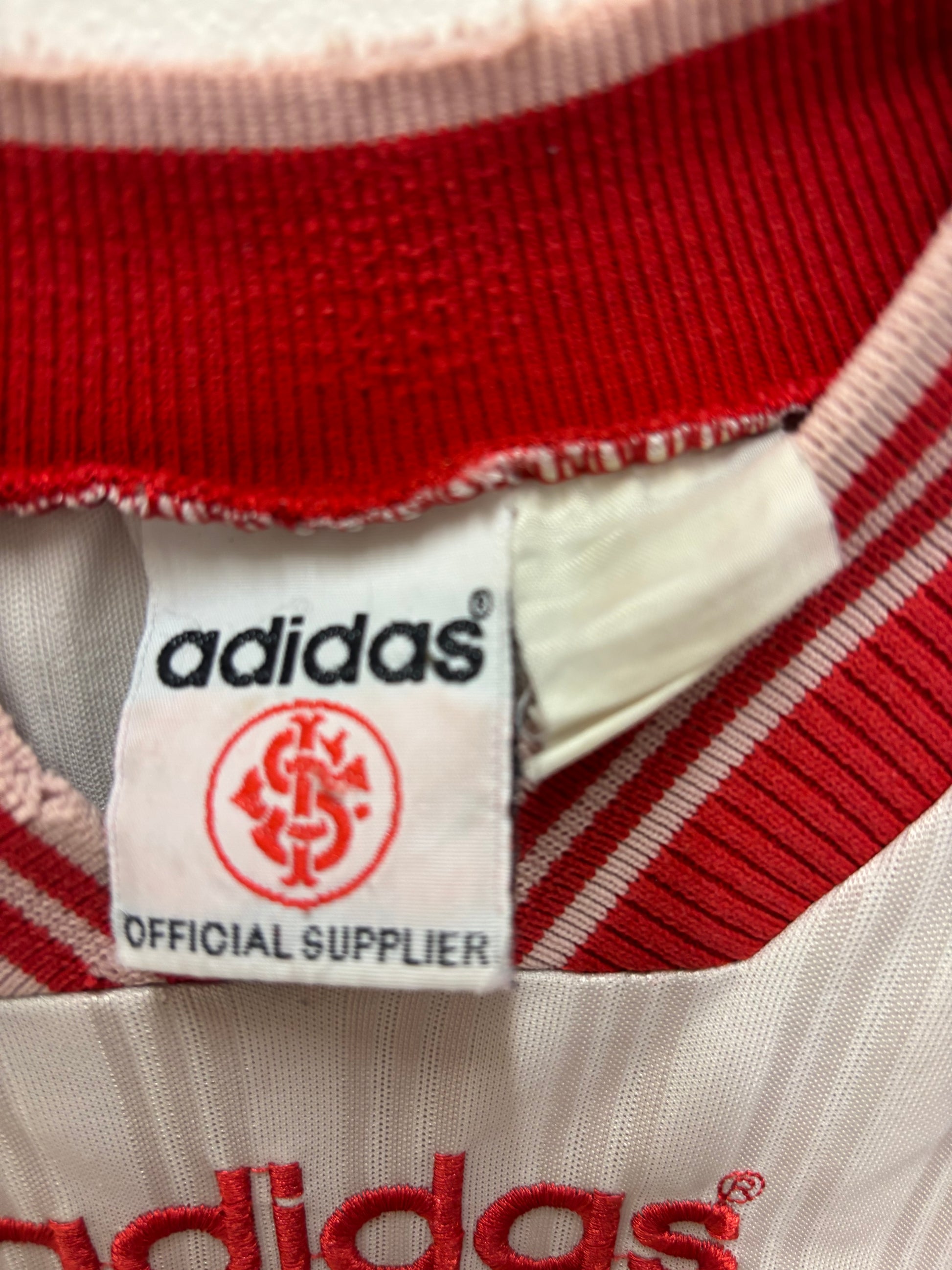 Close-up of an Adidas label on a red and white striped fabric