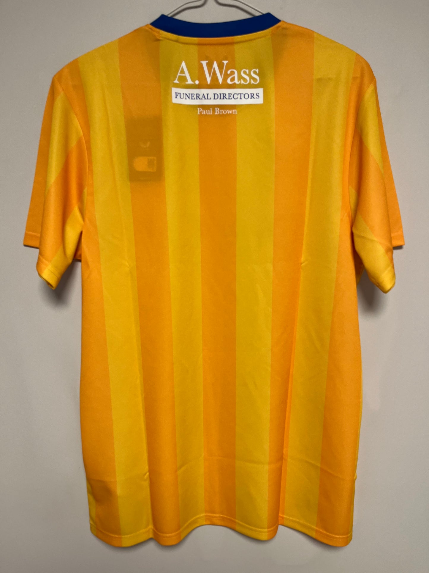 Yellow football jersey with a visible brand label on a gray background