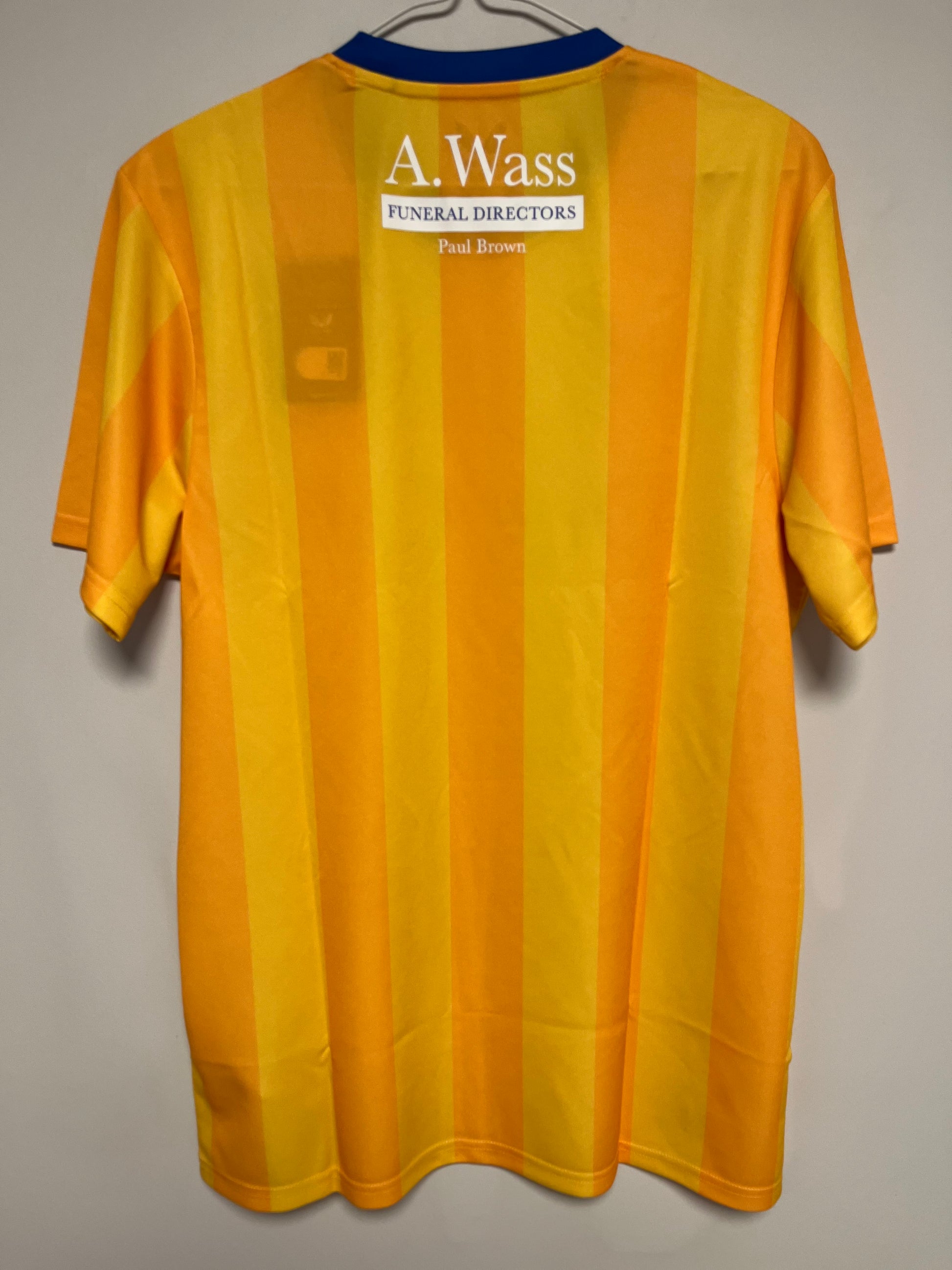 Yellow football jersey with a visible brand label on a gray background