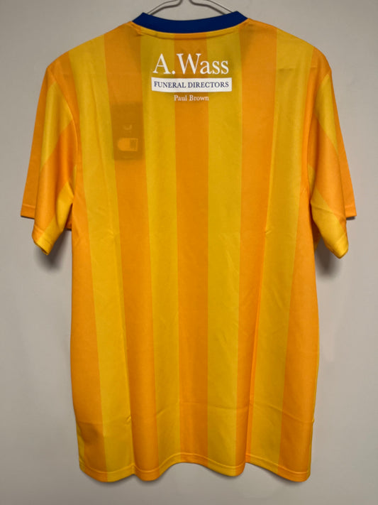 Yellow football jersey with a visible brand label on a gray background