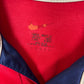 Close-up of Nike swoosh logo and Arsenal club crest on red 99/00 home jersey