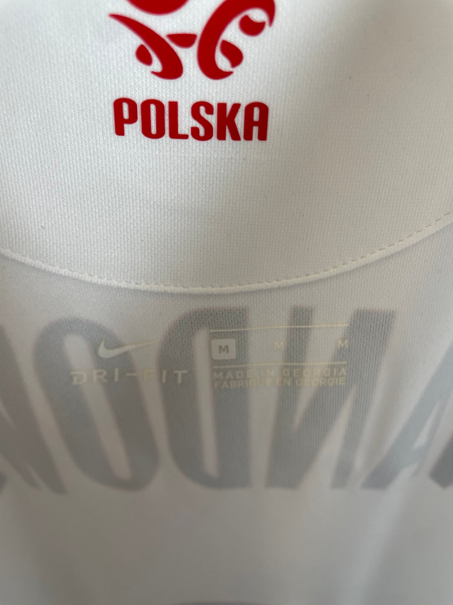Close-up of Poland national team eagle crest and Nike swoosh on white 20/21 home jersey