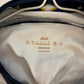 Close-up of a white garment with text inside a navy bag.
