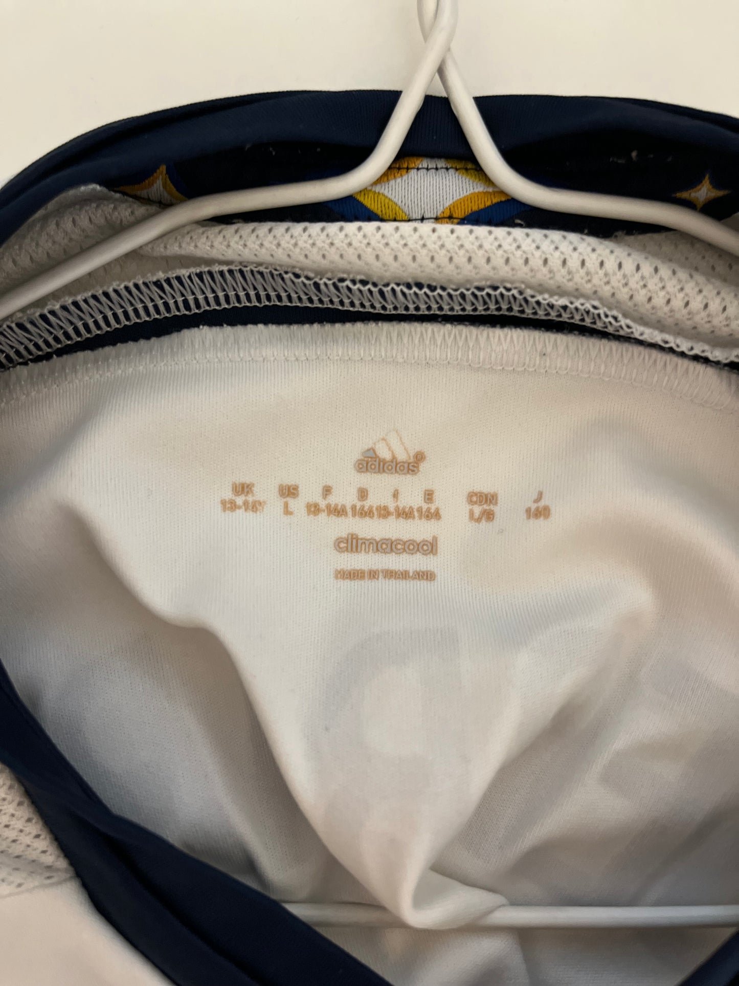 Close-up of a white garment with text inside a navy bag.