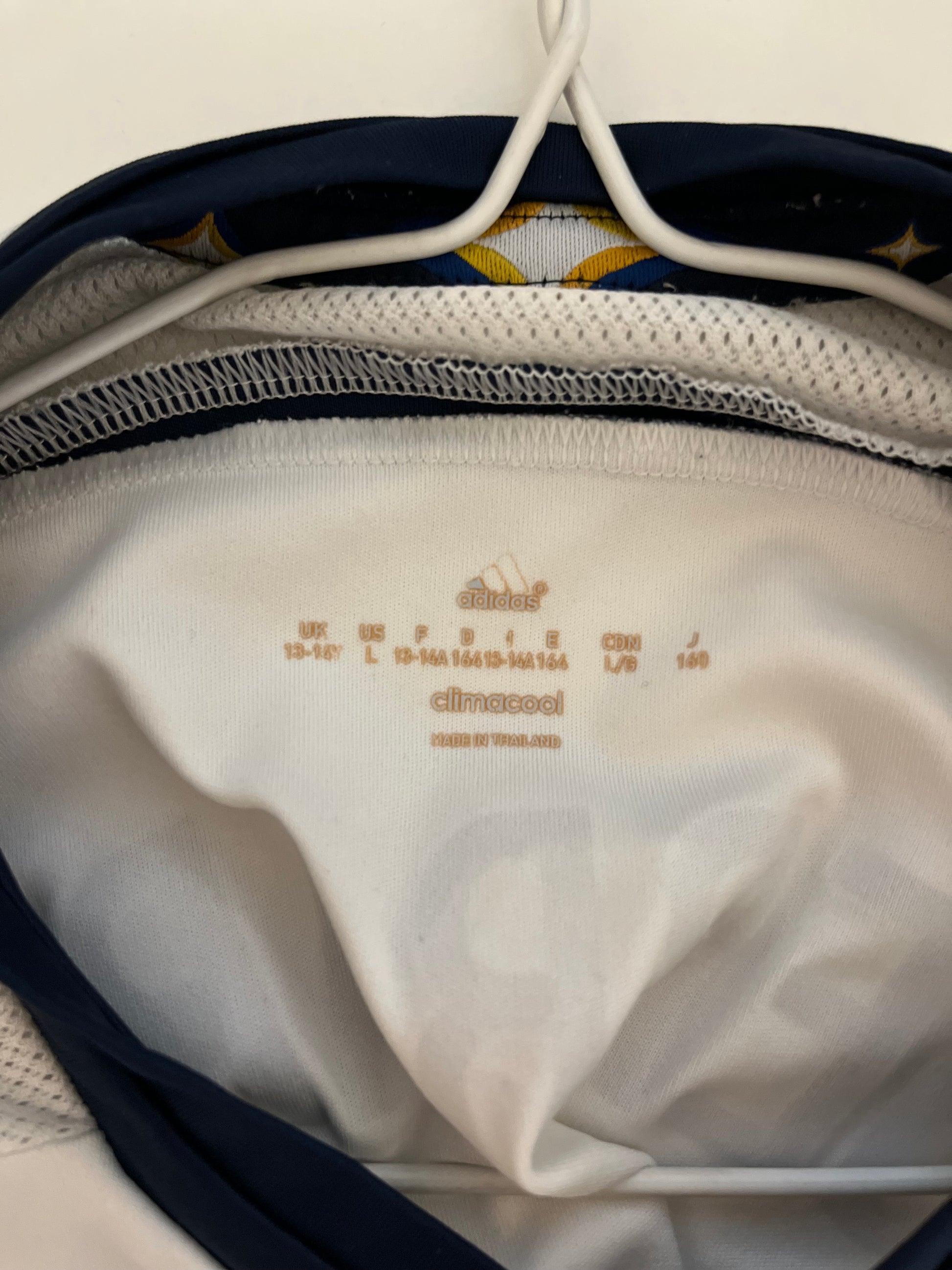 Close-up of a white garment with text inside a navy bag.