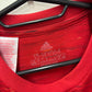 Close-up of Adidas logo and Manchester United club badge on red home shirt 20/21