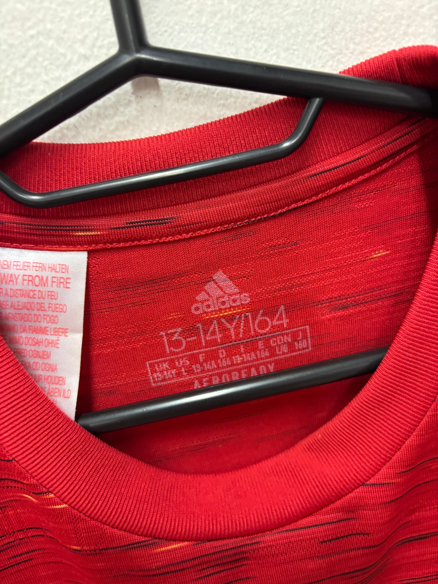 Close-up of Adidas logo and Manchester United club badge on red home shirt 20/21