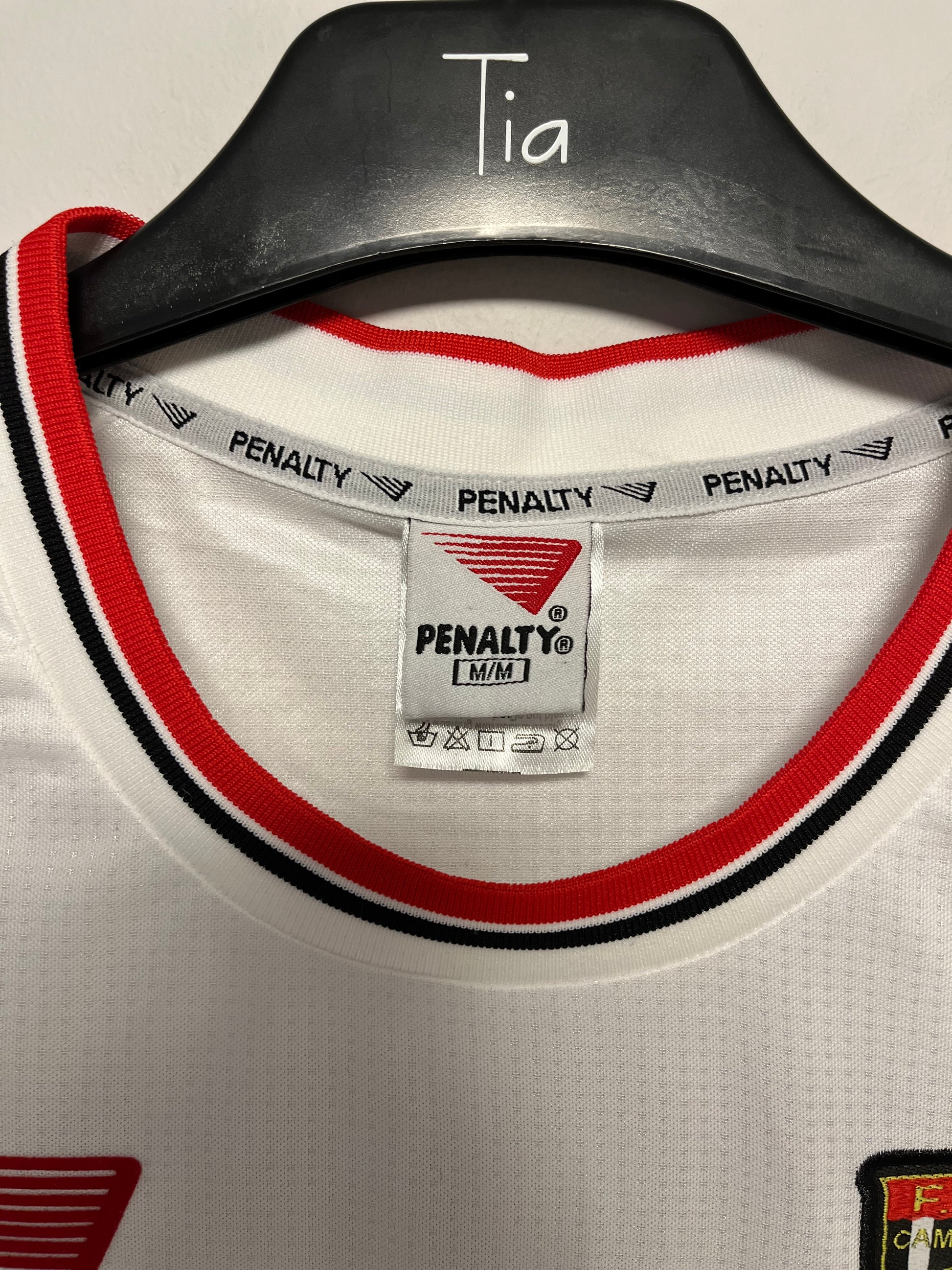 Close-up of a football jersey with Penalty label and black, red, and white design.