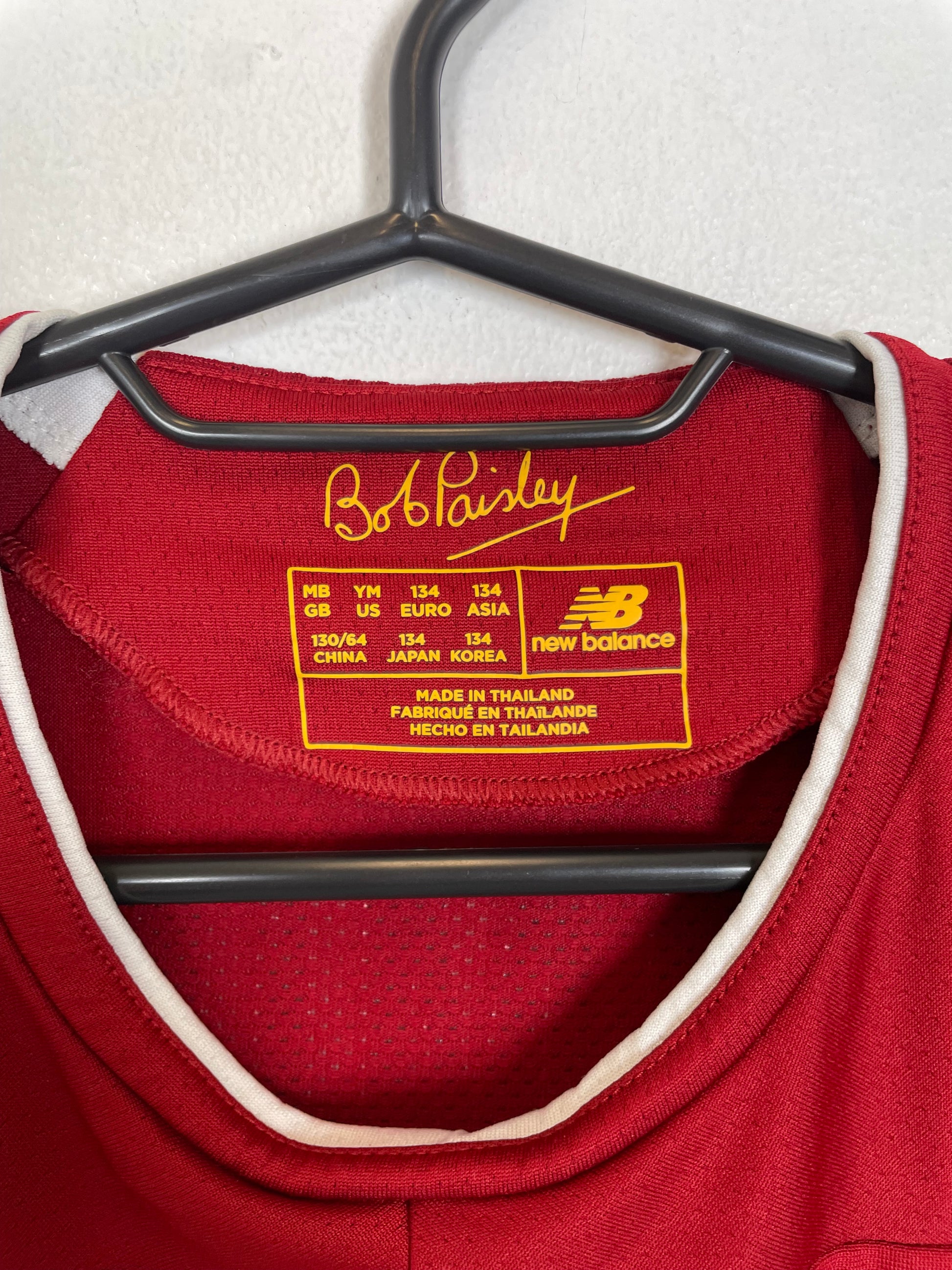 Close-up of New Balance logo and Liverpool club badge on red 19/20 home shirt