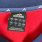 Close-up of Adidas logo and Bayern Munich club badge on 02/03 red home shirt