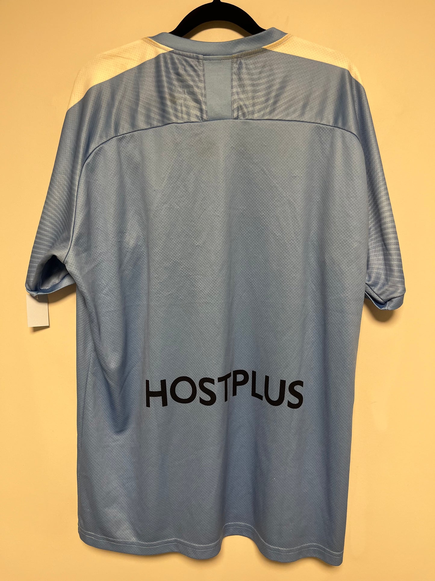 Gray shirt with 'HOSTPLUS' branding on a yellow background