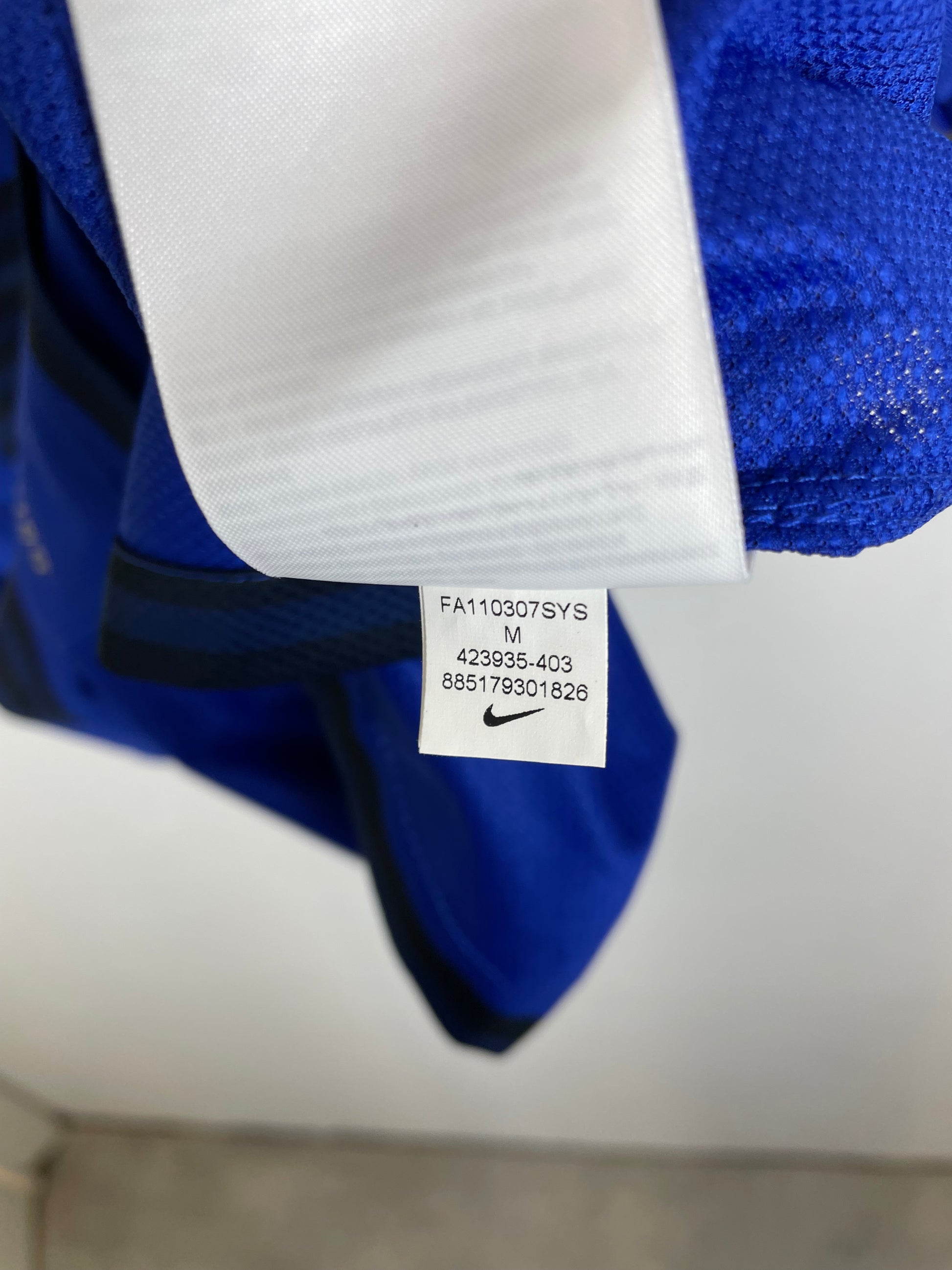 Nike swoosh logo and size tag detail on Manchester United 2011-13 away shirt collar area