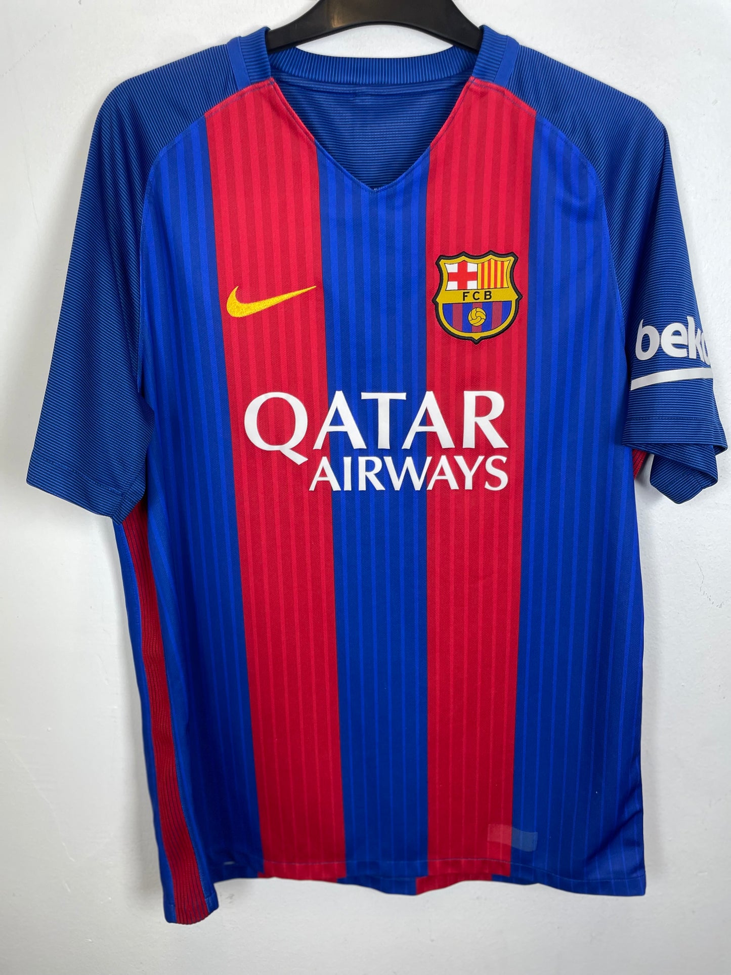 FC Barcelona home soccer jersey with blue and red vertical stripes, featuring the yellow Nike swoosh, FC Barcelona crest, and white Qatar Airways sponsor logo on the front.